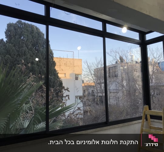 סגירת מרפסת באמצעות חלונות אלומיניום גדולים בפרופיל כהה